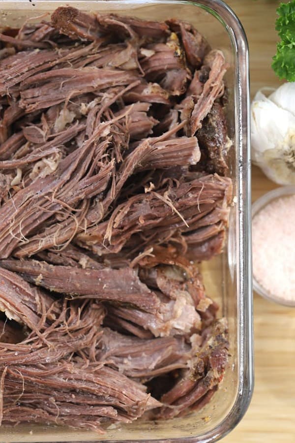 shredded slow cooker rump roast-done cooking and rump roast recipe crock pot ready to serve with mashed potatoes and homemade gravy. 