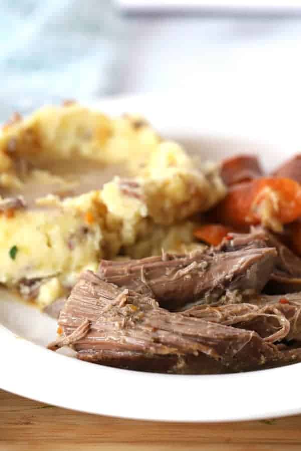 rump roast in slow cooker, served with mashed potatoes and carrots.