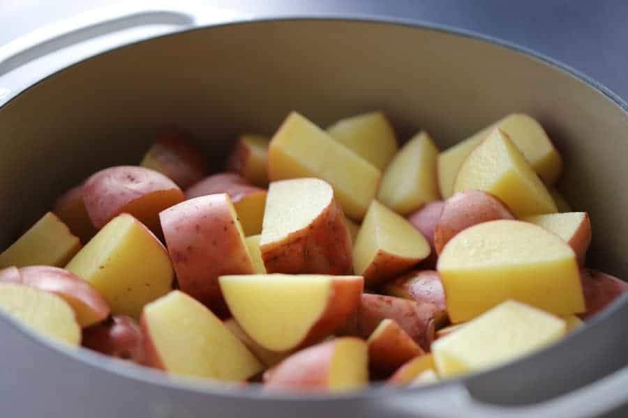raw red potatoes cut in a pot, how to make parmesan garlic mashed potatoes recipe. 