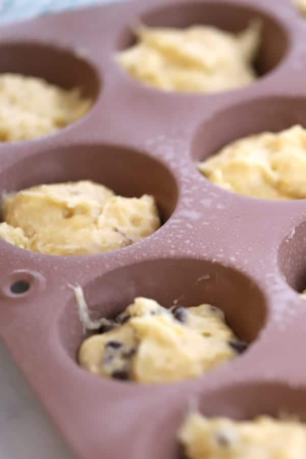 Batter for healthy banana chocolate chip muffins in a muffin tin ready to be baked, how to make banana greek yogurt muffins, yogurt banana muffins.