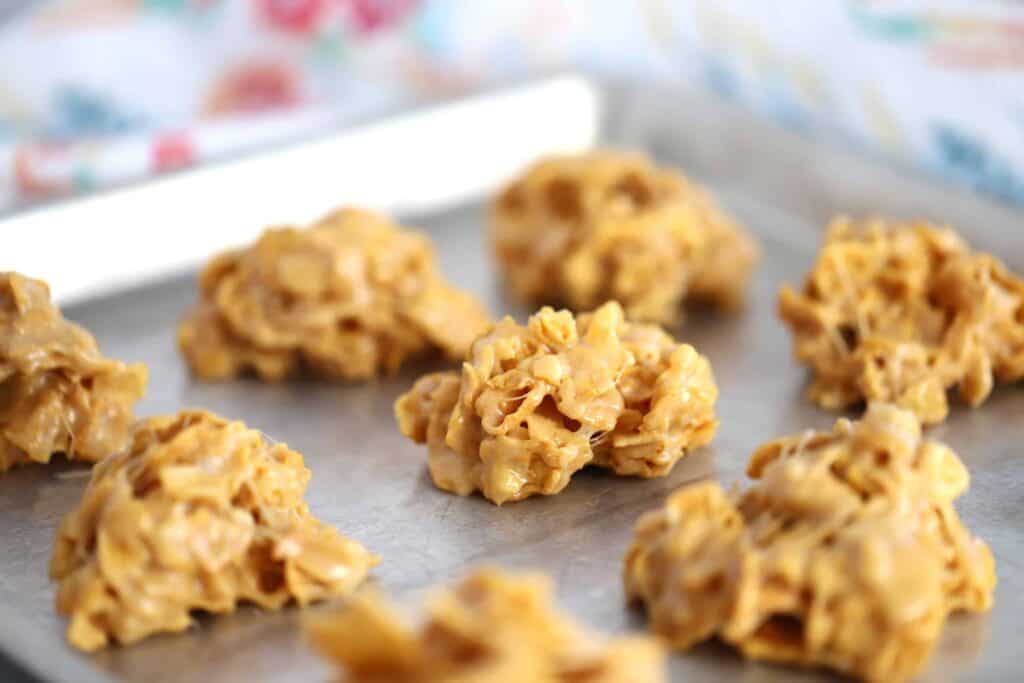 peanut butter cornflake balls on a greased baking sheet, cornflake marshmallow treats