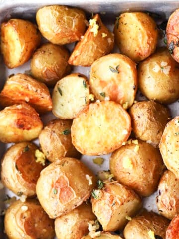 Garlic and Thyme Roasted Potatoes, crispy and chewy and bursting with flavor! boomer gold potatoes, easy oven roasted potatoes.