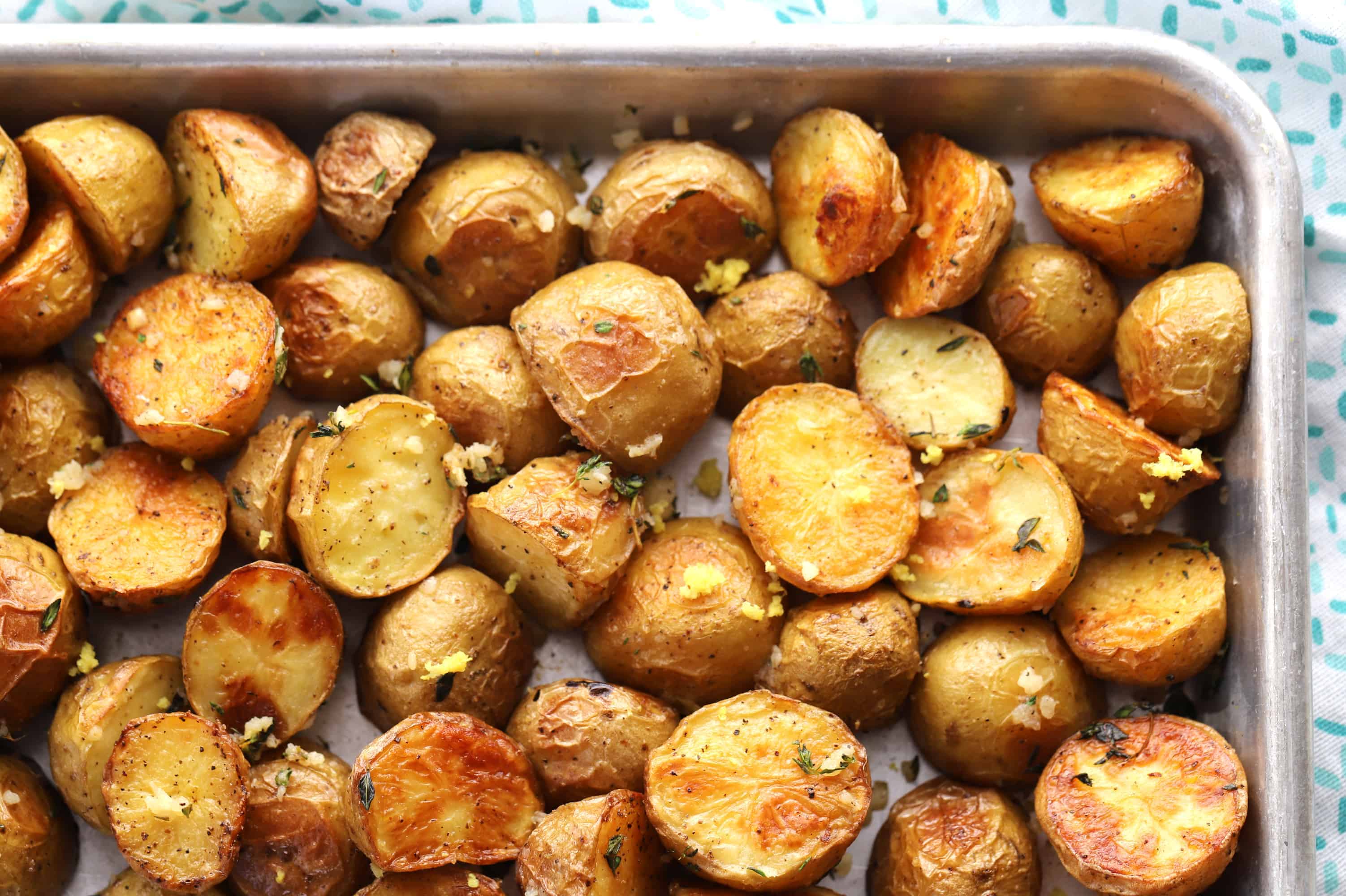 Oven Roasted Potatoes on a baking sheet. roasted potatoes in oven, oven baked roasted potatoes, small gold potatoes. baked gold potatoes.