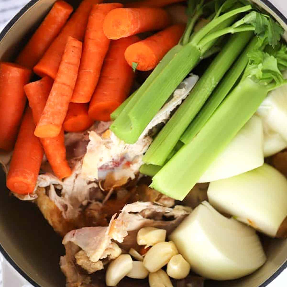 ngredients to make homemade chicken stock in a large pot.