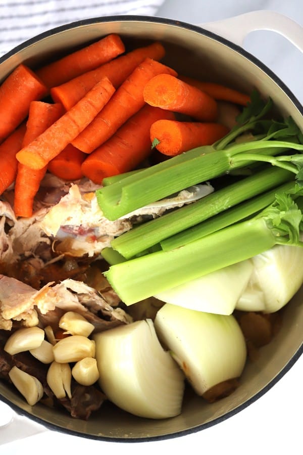 A large stockpot full of chicken bones, carrots, celery, onions and garlic to make Chicken Stock. homemade chicken stock with chicken carcass. 