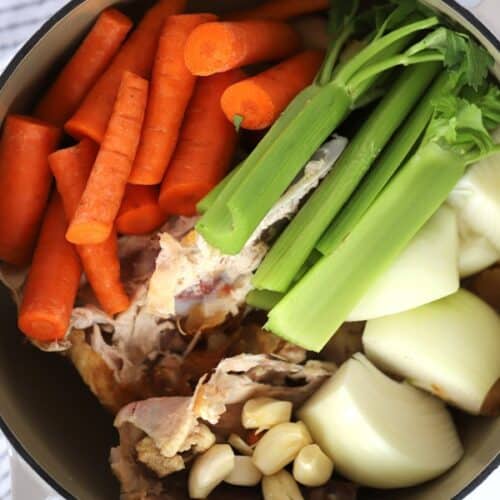 Ingredients to make homemade chicken stock in a large pot.