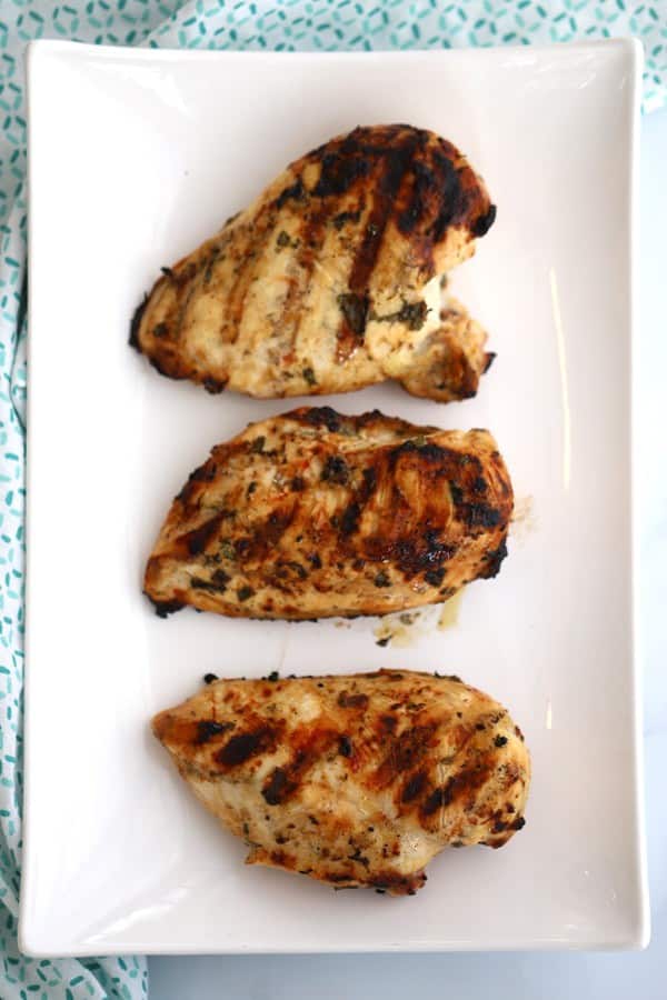 Grilled cilantro lime chicken breast on a white plate.