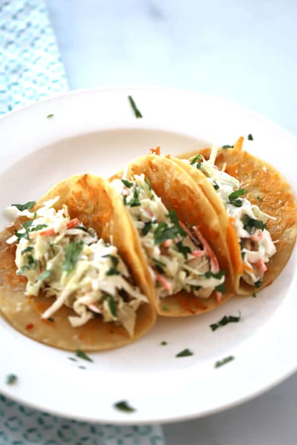 Cilantro lime chicken crockpot tacos on a white plate.