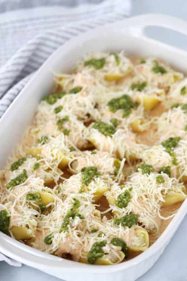 chicken and cheese stuffed pasta shells unbaked with mozzeralla and pesto drizzle