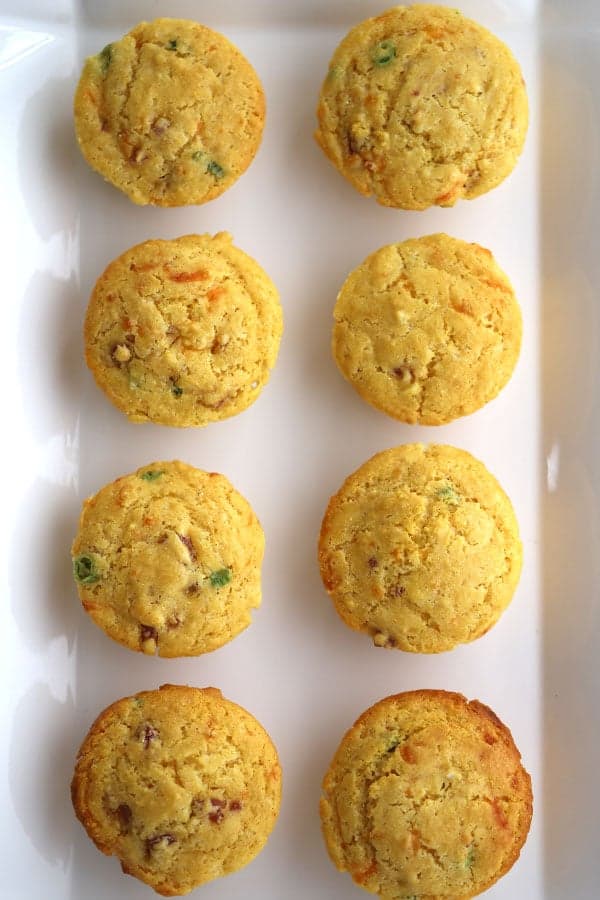 A plate of corn meal muffins lined up in rows. corn muffin recipe on a platter. 