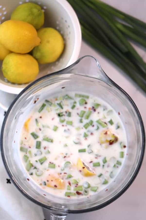 Buttermilk Ginger Marinade in a pitcher with a small bowl of lemons on the side. Grilled salmon recipe.