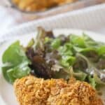 Cornflake fried Chicken on a dinner plate with a green salad, ready to eat.