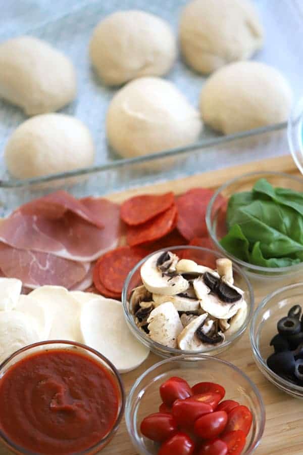 How to make homemade pizza sauce with tomato sauce, pizza toppings on a wood surface with balls of pizza dough recipe. how to make pizza crust, how to cook pizza dough, temperature for pizza dough.