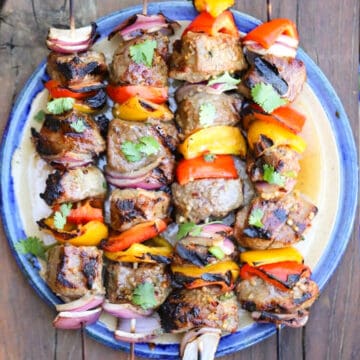 beef shish kabobs cooked after a marinade for beef kabobs. and on a plate, marinade for shish kabobs, beef shish kabob.