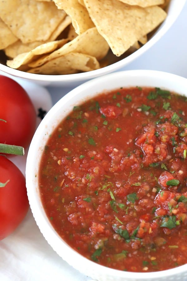 fresh salsa in a bowl with a side bowl of tortilla chips.