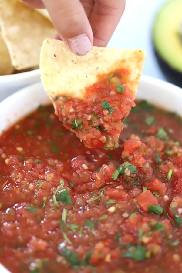 how to make salsa. Salsa in a serving bowl with tortilla chip