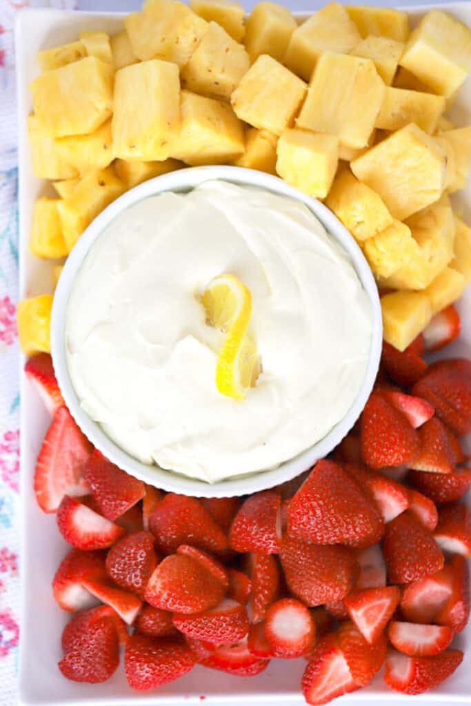 lemon Cheesecake Fruit dip on a platter wiith fresh strawberries and pineapple