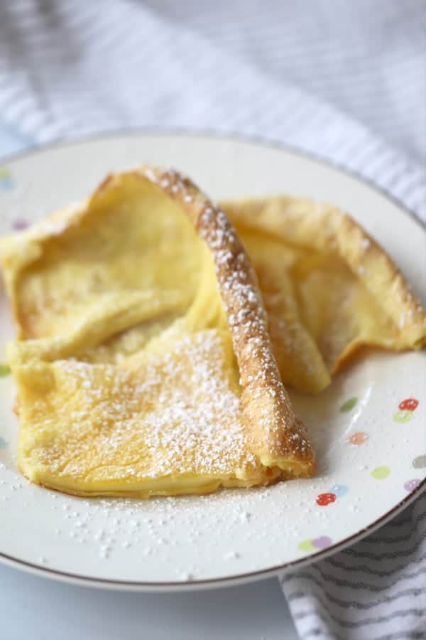 Einkorn German Pancakes on a plate topped with powdered sugar. A delicious einkorn flour recipe that can double as an aebleskiver recipe with the right pan.