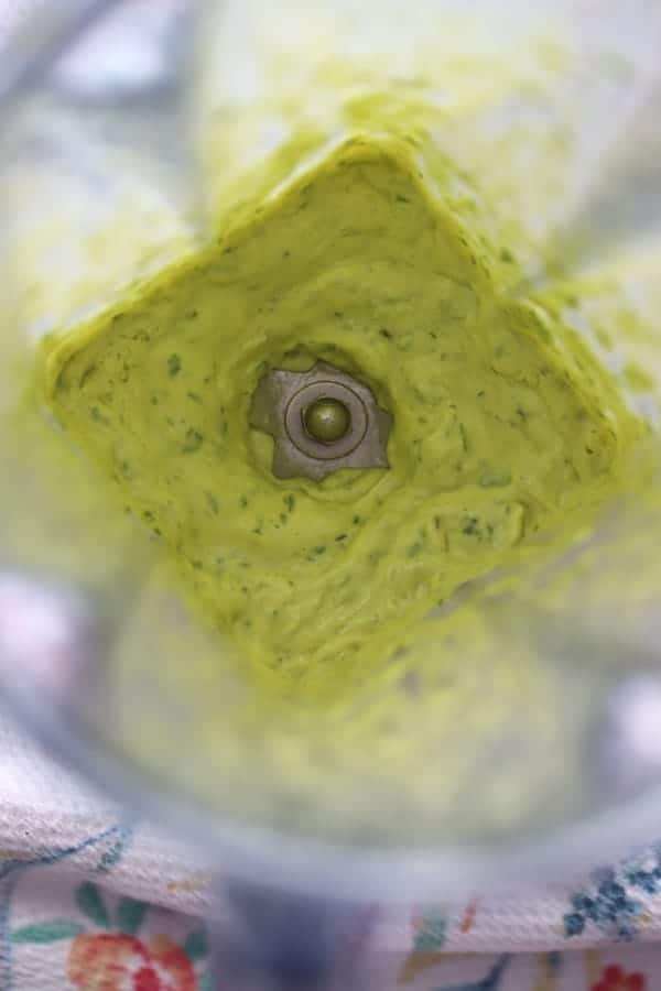 A blender with garlic basil aioli blending.