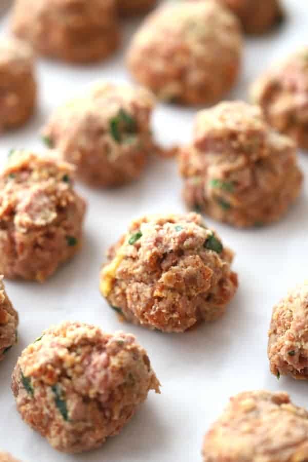 raw italian meatballs on a baking sheet ready to cook 