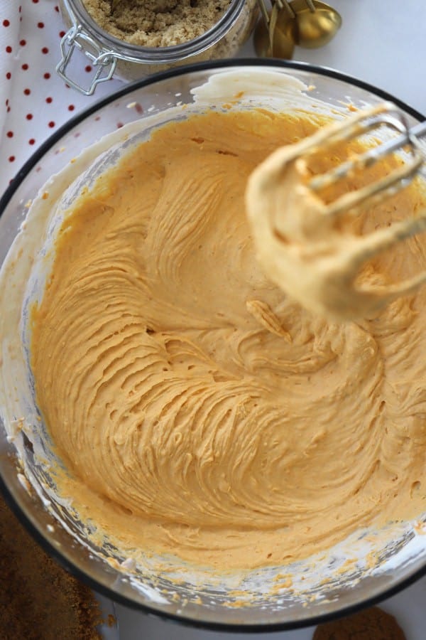 No-bake pumpkin cheesecake filing in a bowl with an electric mixer.