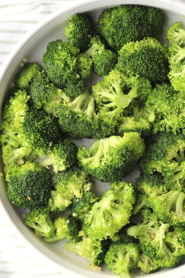 roasted broccoli recipe in a white round baking dish, oven baked broccoli, roasted garlic broccoli, roasted broccoli garlic lemon. 
