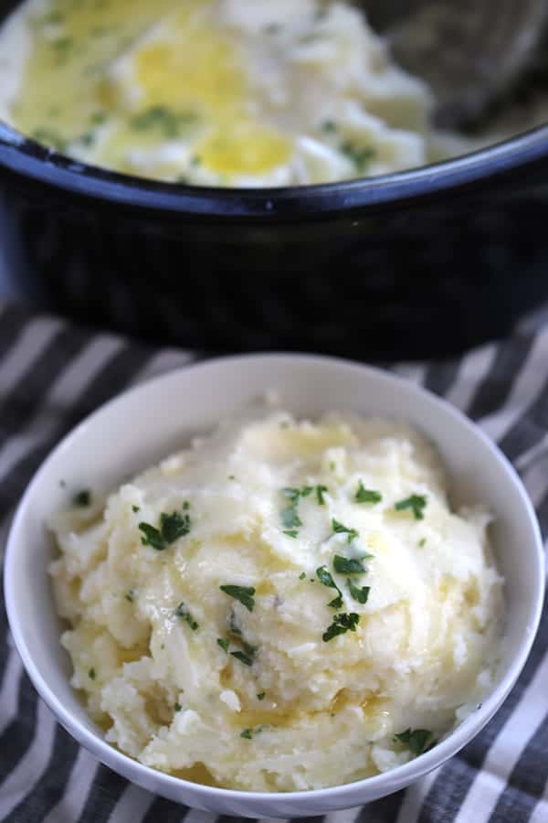 crockpot mashed potatoes in a bowl topped with chopped parsley