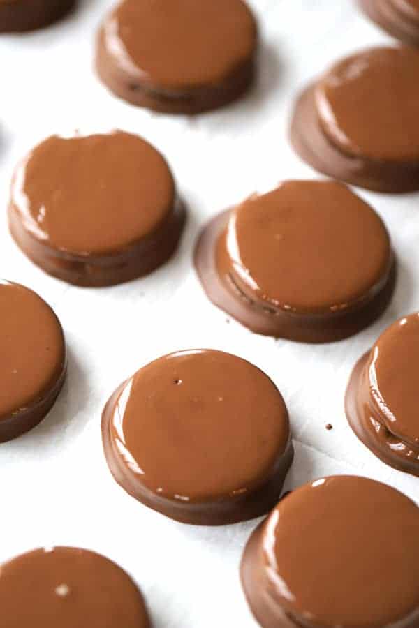 Fudge covered mint oreos on a baking sheet. This recipe is for making oreo mints, one of our favorite recipes using andes mints.