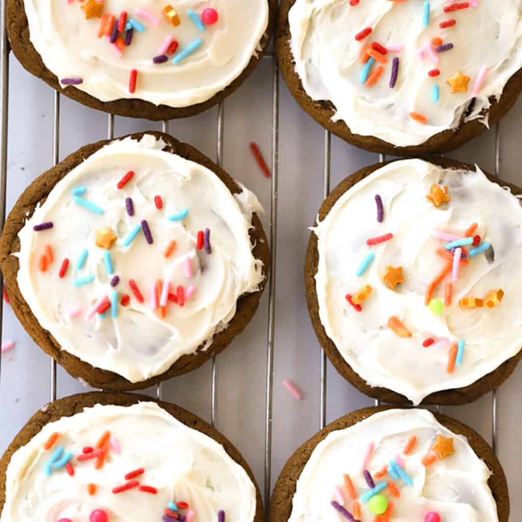 Molasses cookies with white buttercream frosting and sprinkles.
