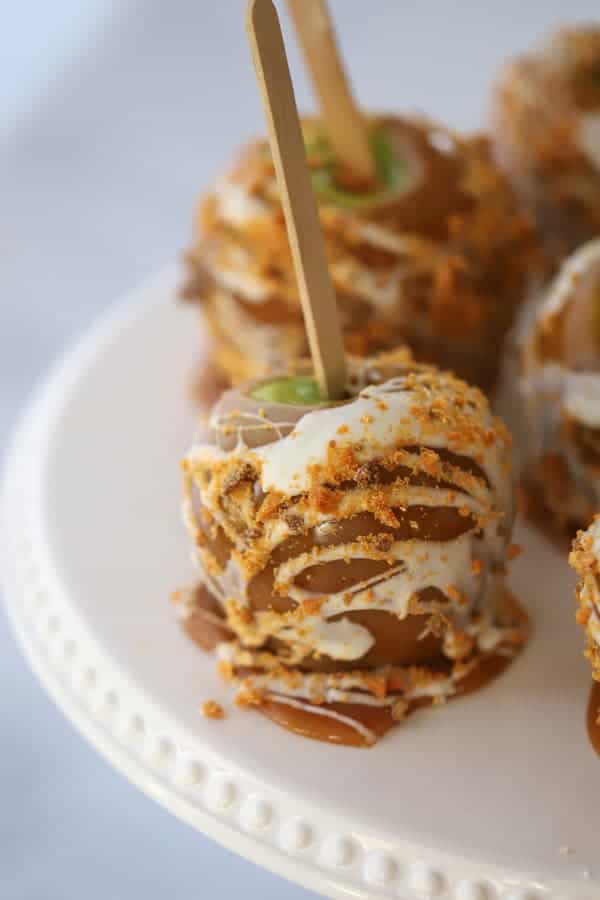 Homemade caramel apples on a serving plate.