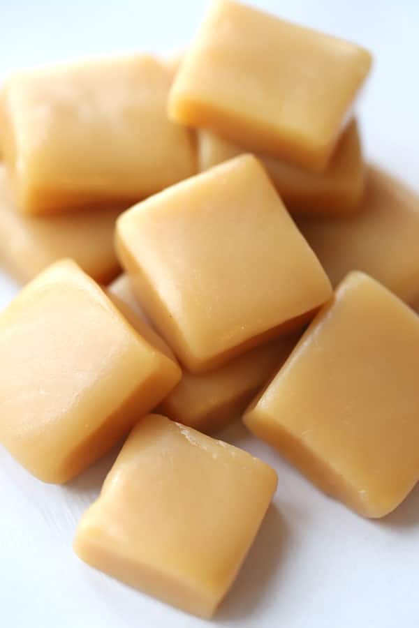A pile of cut caramel squares on a table.