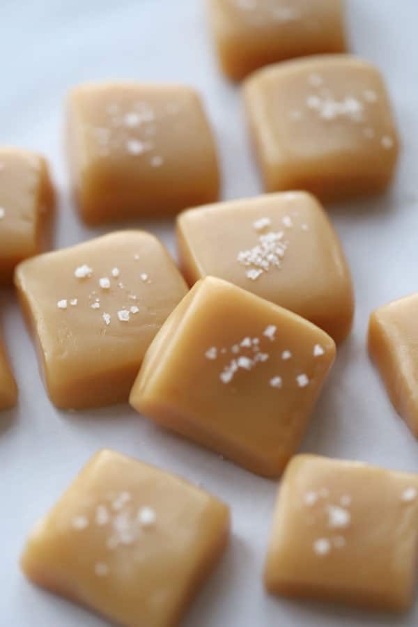 Caramel candies topped with sea salt on a table.