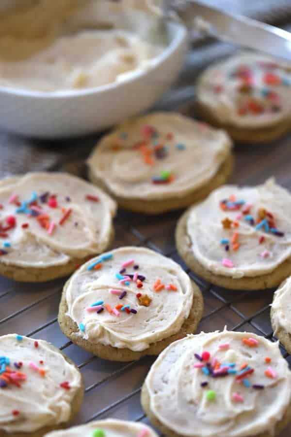 egg nog christmas cookies on a wire cooling rack with egg nog frosting and sprinkles.