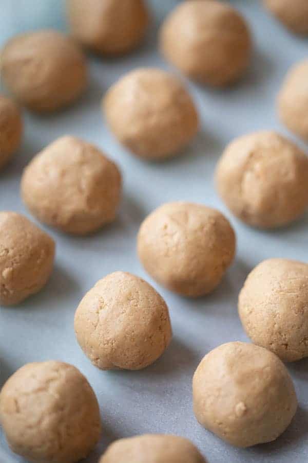 Peanut butter balls recipe, peanut buitter balls rolled up on a baking sheet, how to make peanut butter balls, how to make buckeye balls.