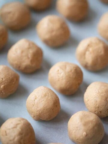 Peanut butter balls recipe, peanut buitter balls rolled up on a baking sheet