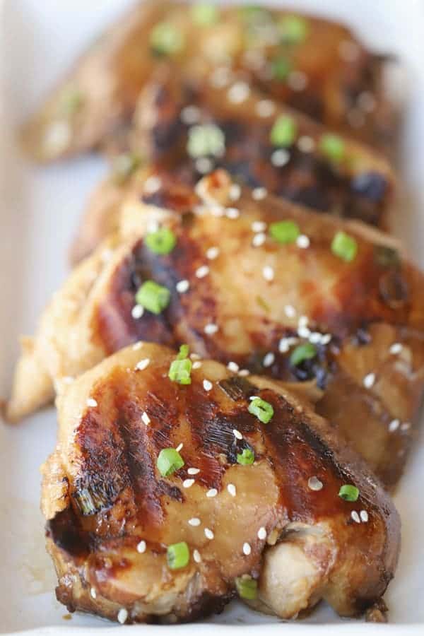 Grilled Teriyaki Chicken on a plate garnished with sliced green onions.