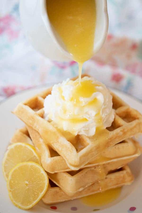 lemon syrup recipe being poured over waffles and whipped cream