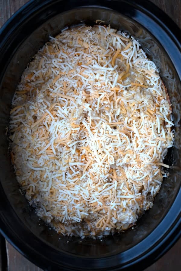 Crock pot potatoes with cheese in a slowcooker, cheesy hashbrowns in crockpot, crockpot cheesy hashbrown potatoes.