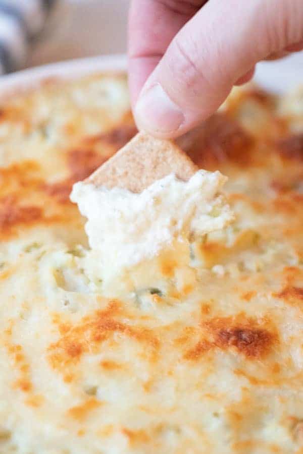 artichoke jalapeno dip with a cracker