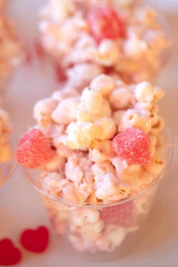 White chocolate covered popcorn in a plastic cup.