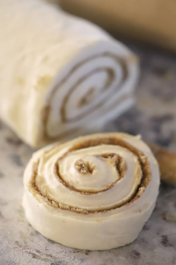 Homemade cinnamon rolls being cut, and ready to bake, 