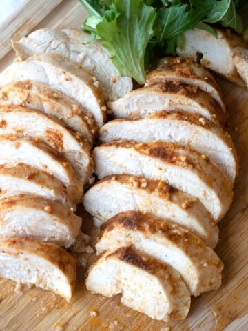 best baked chicken breast on a wood cutting board