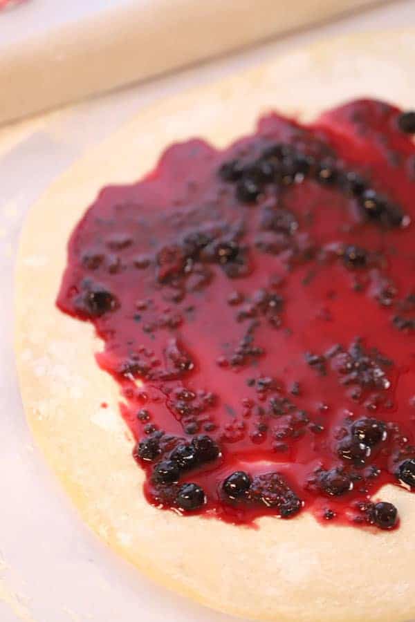 Sweet roll dough rolled out into a rectangle and covered with berry compote.