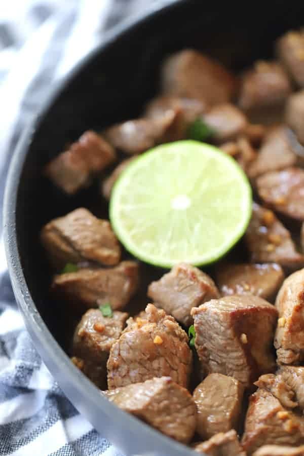 chili lime steak bites in a dark pan, honey garlic steak bites, steak appetizer bites, asian steak bites.