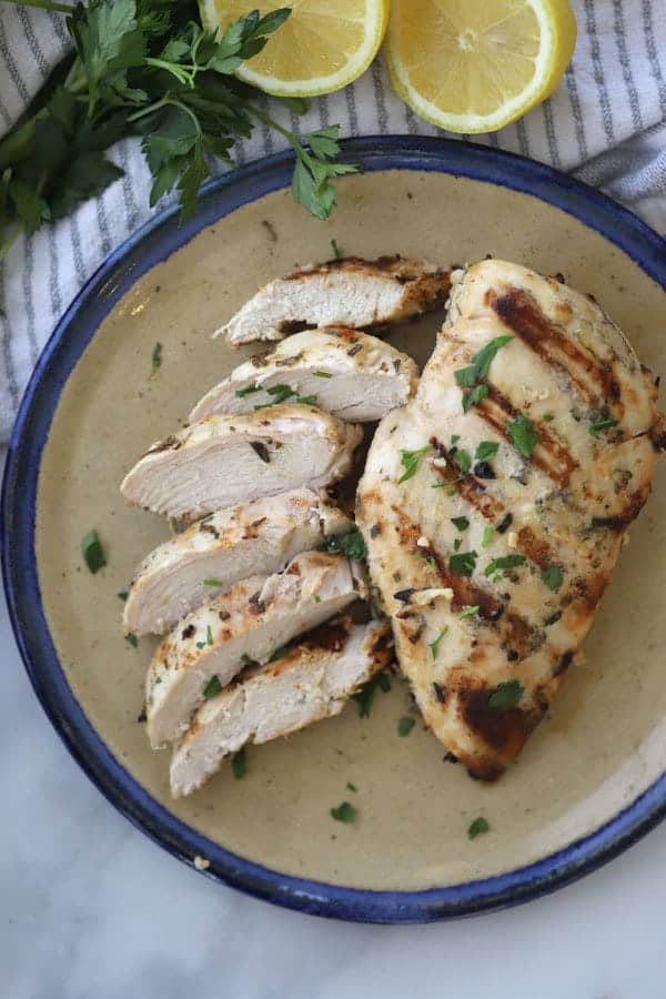 A plate with grilled chicken breasts, marinated chicken with rosemary and garlic.