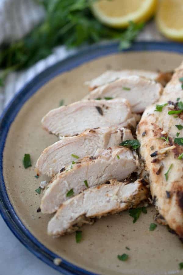 Grilled rosemary garlic chicken sliced on a plate. 