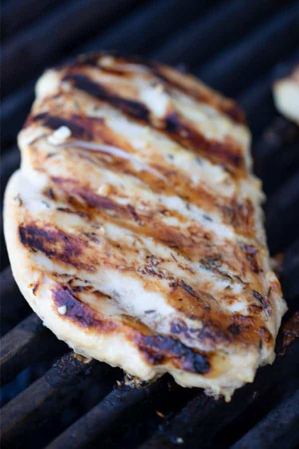 Grilled rosemary chicken breast on a hot grill.