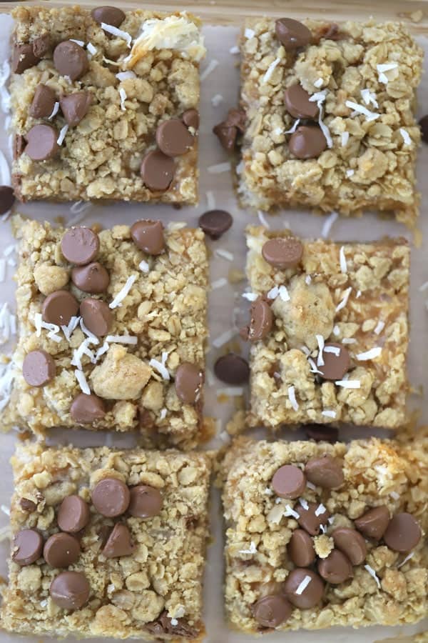 Coconut Caramel Magic Bars on a cutting boars
