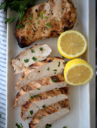 honey mustard chicken with a lemon wedge on a white plate