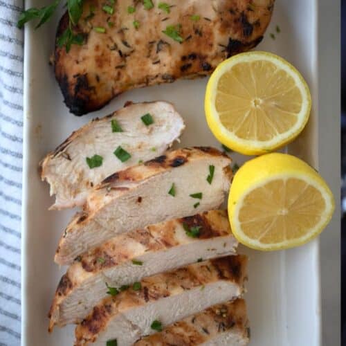 honey mustard chicken with a lemon wedge on a white plate